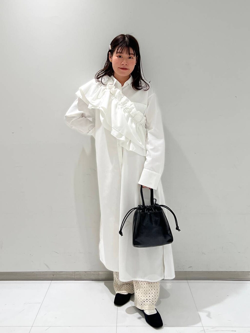 ホワイト系のその他パンツ、その他のパンプス、ブラック系のハンドバッグを着用したレディースの冬コーディネートの2枚目の写真