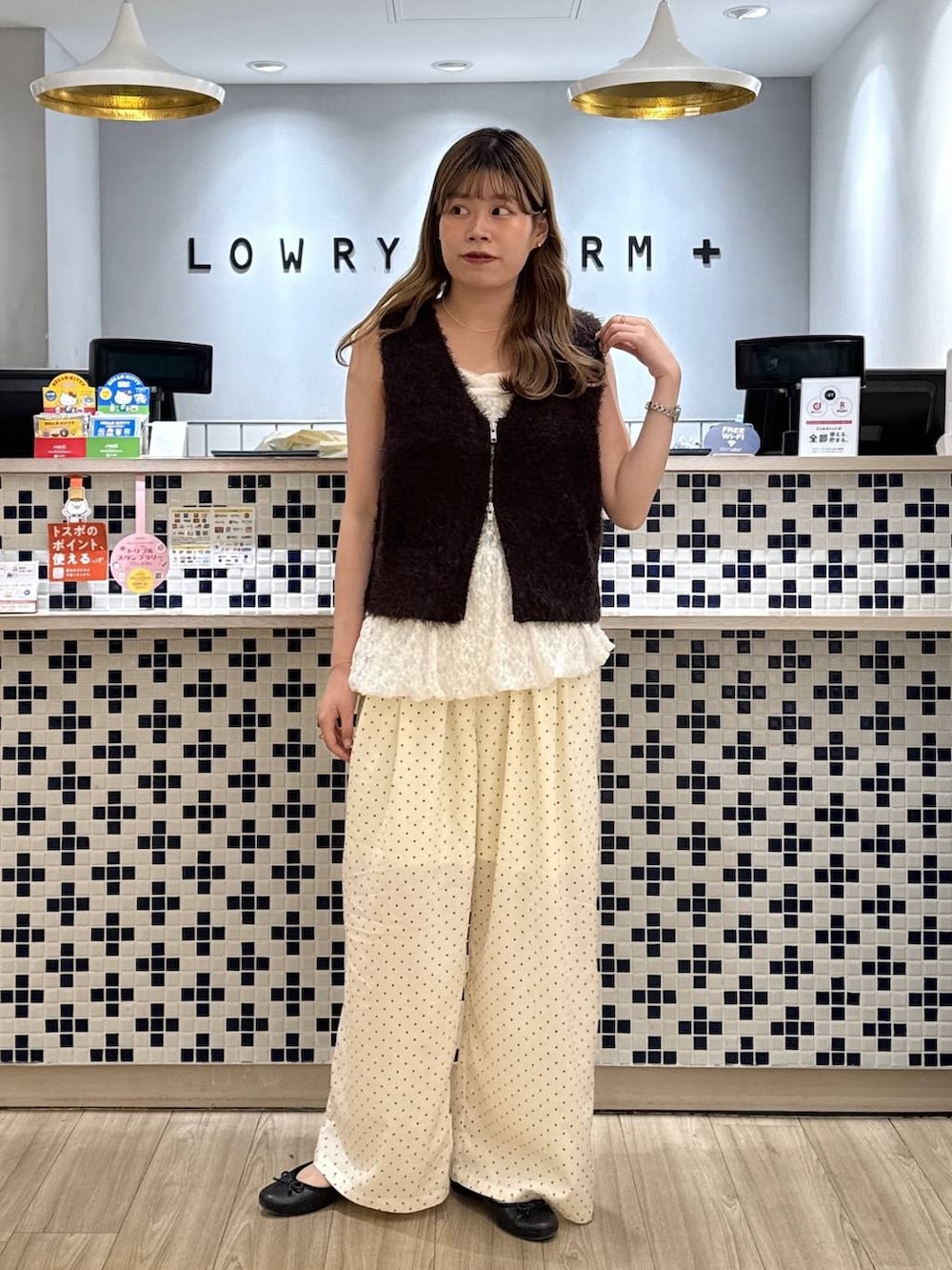 ホワイト系のキャミソール、ホワイト系のその他パンツ、ブラウン系のベストを着用したレディースの秋コーディネートの2枚目の写真