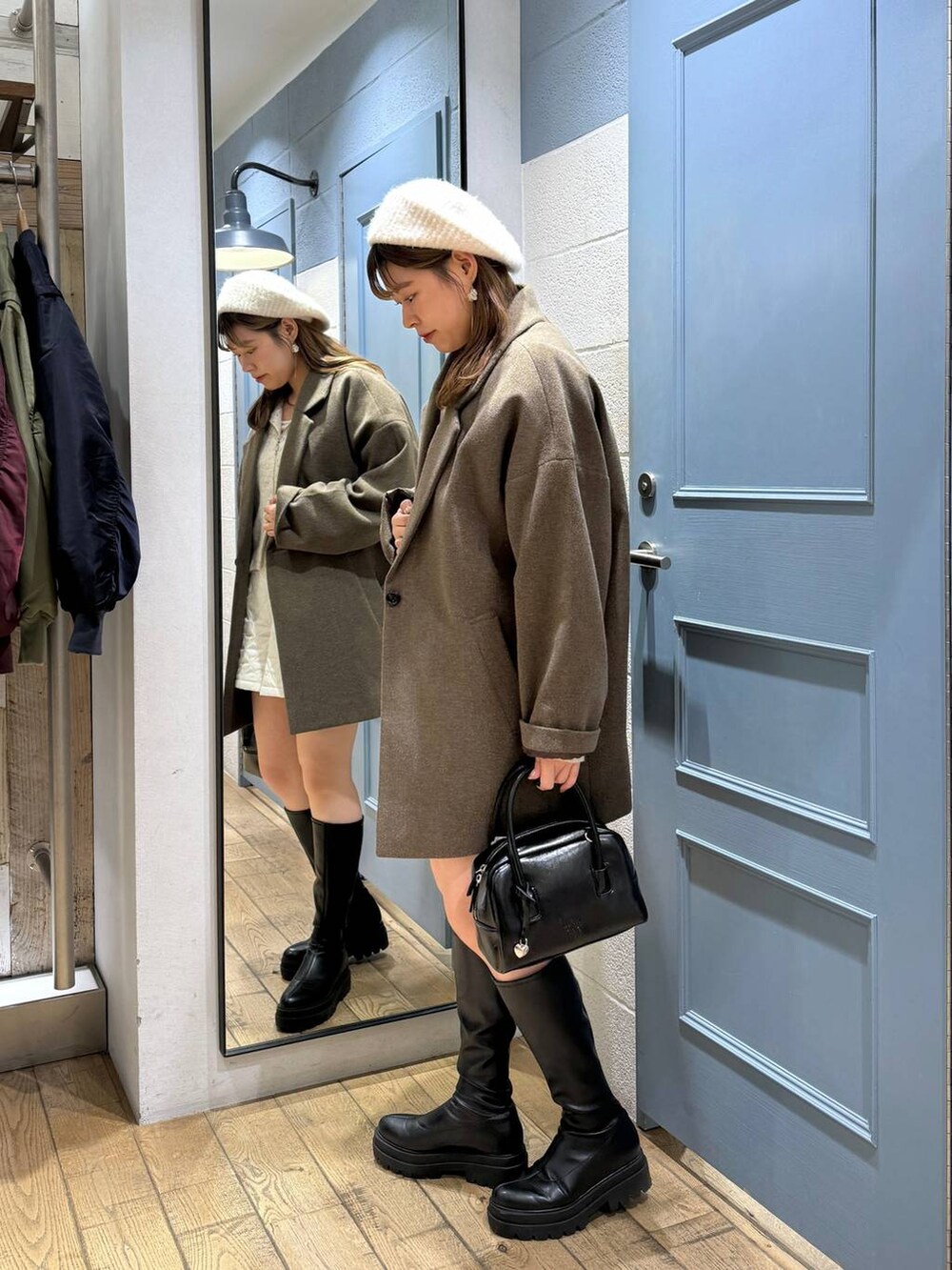 ブラウン系のチェスターコート、ホワイト系のその他パンツ、ブラック系のブーツを着用したレディースの秋コーディネートの4枚目の写真
