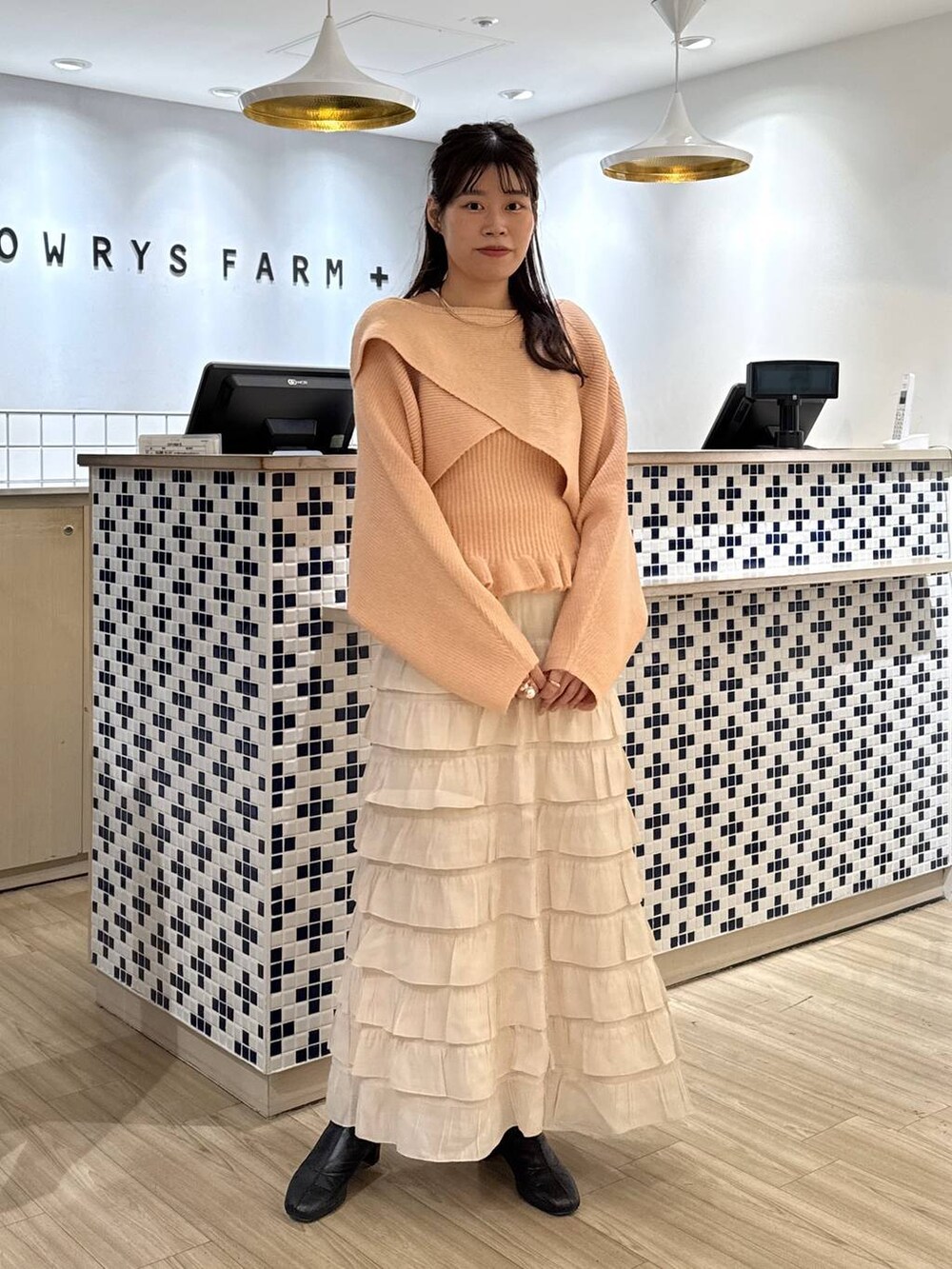 ホワイト系のスカート、ピンク系のニット/セーター、ブラック系のブーツを着用したレディースの秋コーディネートの3枚目の写真