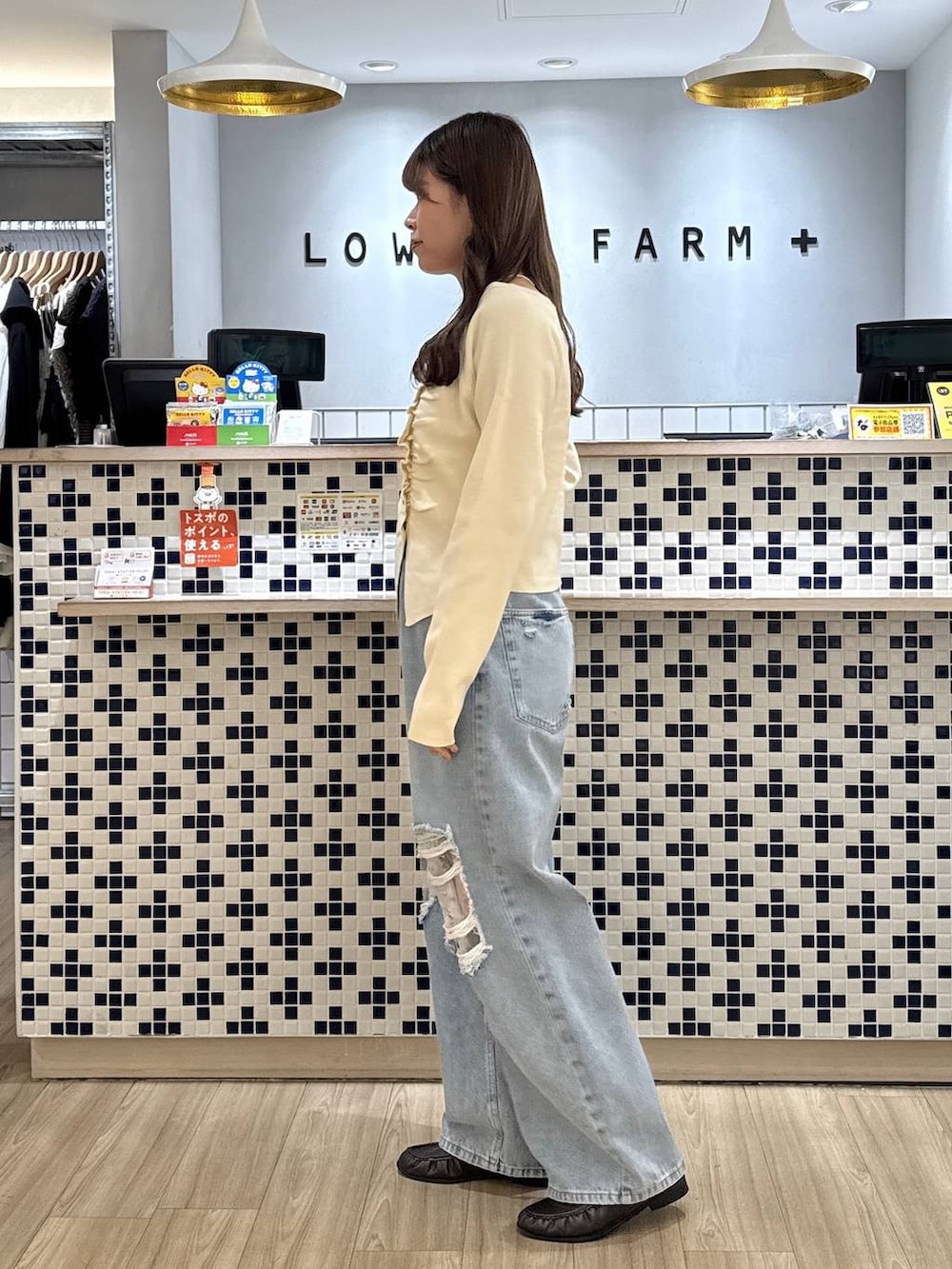 ホワイト系のニット/セーター、ブラウン系のローファー、ブルー系のデニムパンツを着用したレディースの秋コーディネートの4枚目の写真