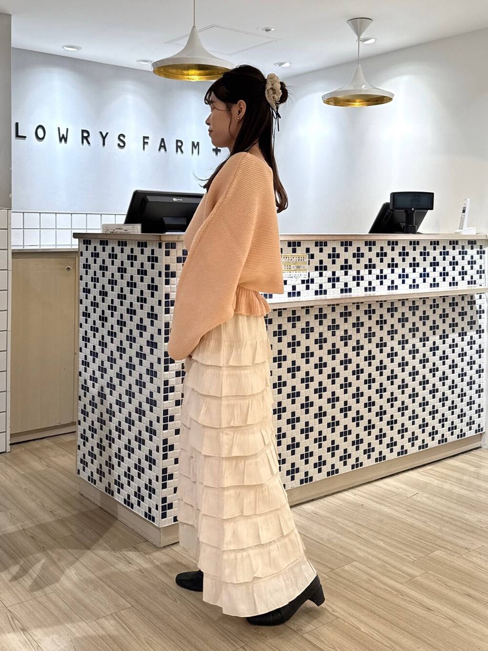 ホワイト系のスカート、ピンク系のニット/セーター、ブラック系のブーツを着用したレディースの秋コーディネートの4枚目の写真