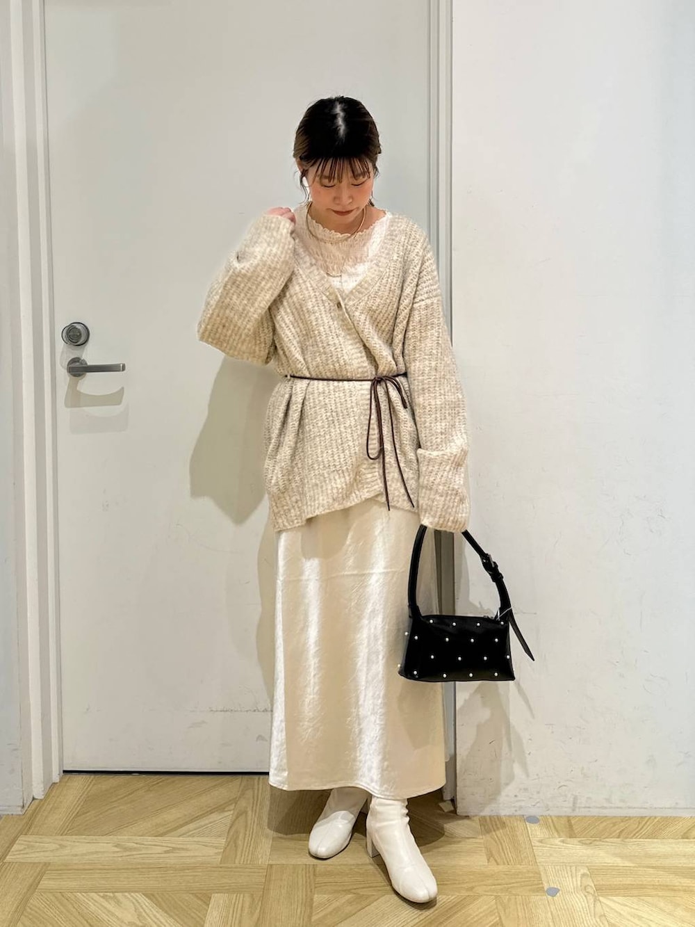 ホワイト系のスカート、ホワイト系のブーツ、ホワイト系のTシャツ/カットソーを着用したレディースの秋コーディネートの2枚目の写真