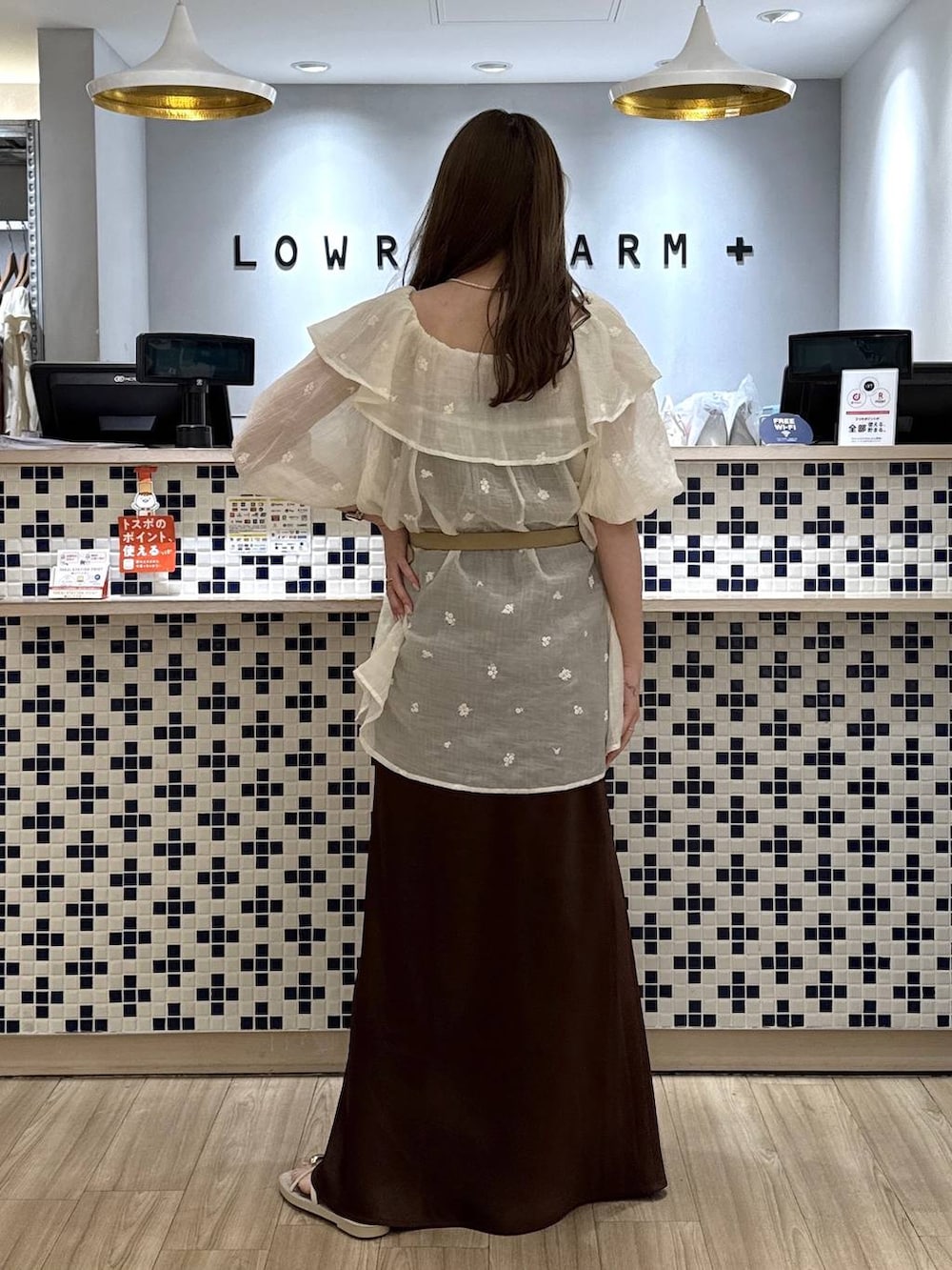 ホワイト系のワンピース、ブラウン系のスカート、ホワイト系のサンダルを着用したレディースの夏コーディネートの5枚目の写真