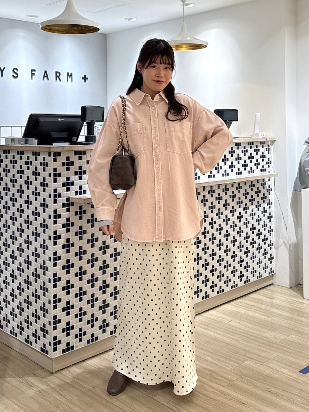 ホワイト系のスカート、ブラウン系のブーツ、ピンク系のシャツ/ブラウスを着用したレディースの冬コーディネートの2枚目の写真