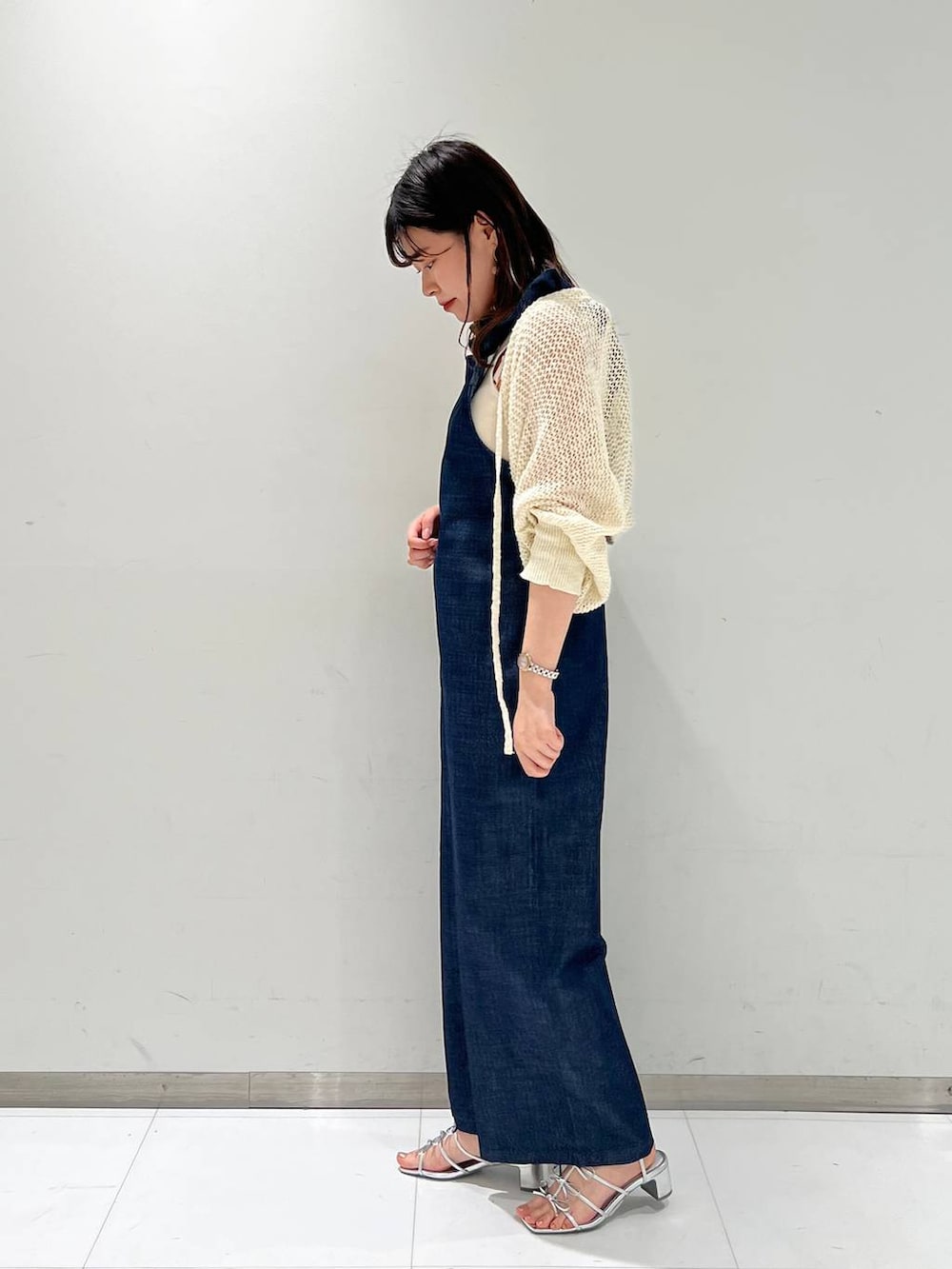 シルバー系のサンダル、ホワイト系のカーディガン/ボレロ、ブルー系のサロペット/オーバーオールを着用したレディースの夏コーディネートの2枚目の写真