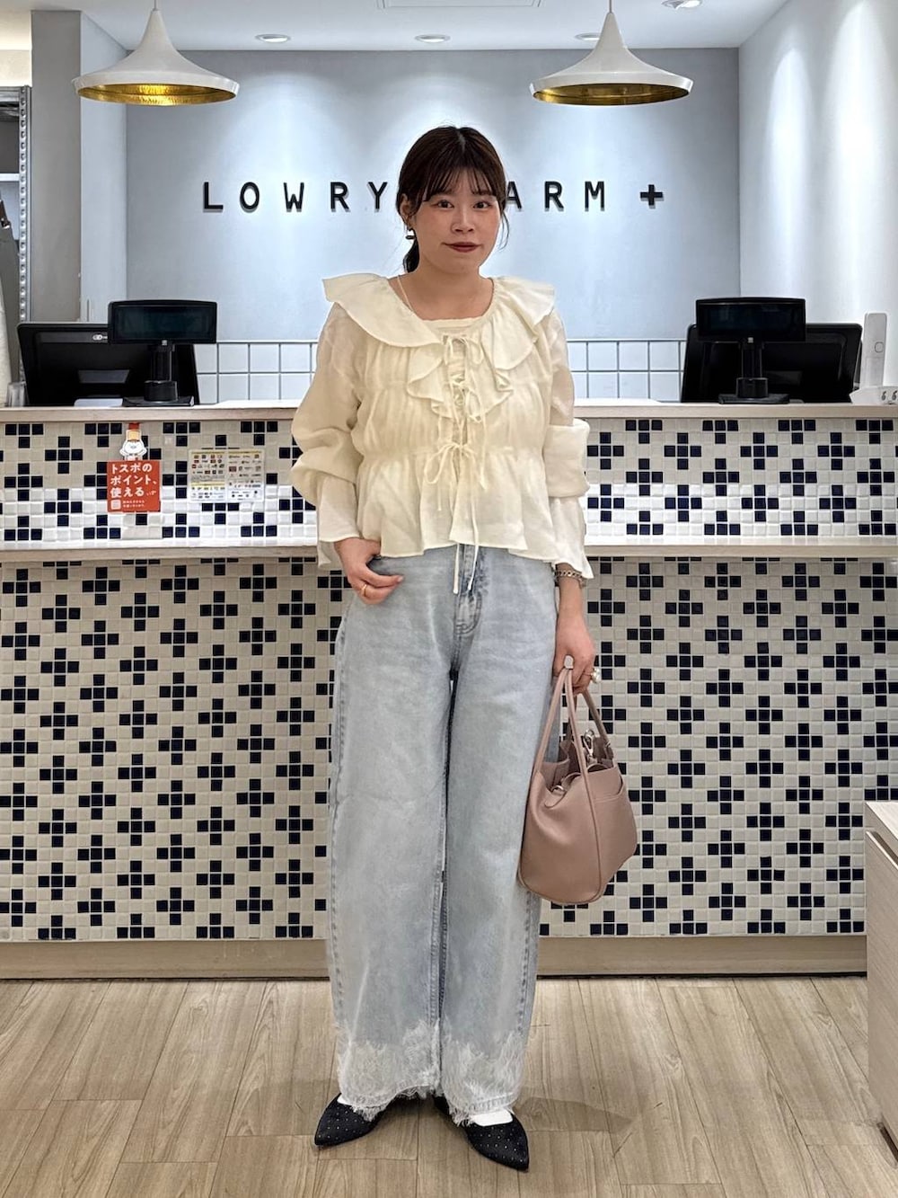 ホワイト系のショルダーバッグ、ブラック系のパンプス、ブルー系のデニムパンツを着用したレディースの春コーディネートの2枚目の写真