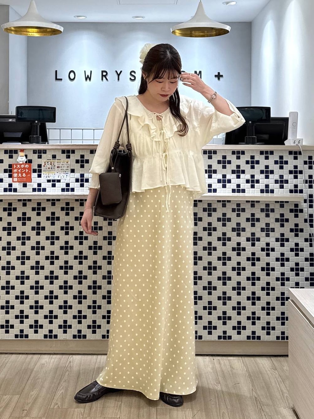 ホワイト系のスカート、ブラウン系のローファー、ホワイト系のタンクトップを着用したレディースの春コーディネートの3枚目の写真