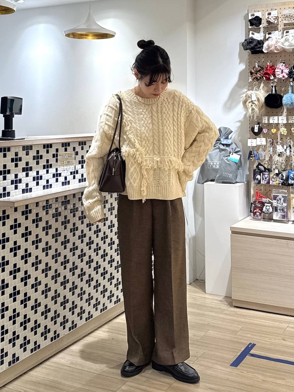 ブラウン系のその他パンツ、ブラック系のローファー、ホワイト系のポロシャツを着用したレディースの秋コーディネートの3枚目の写真