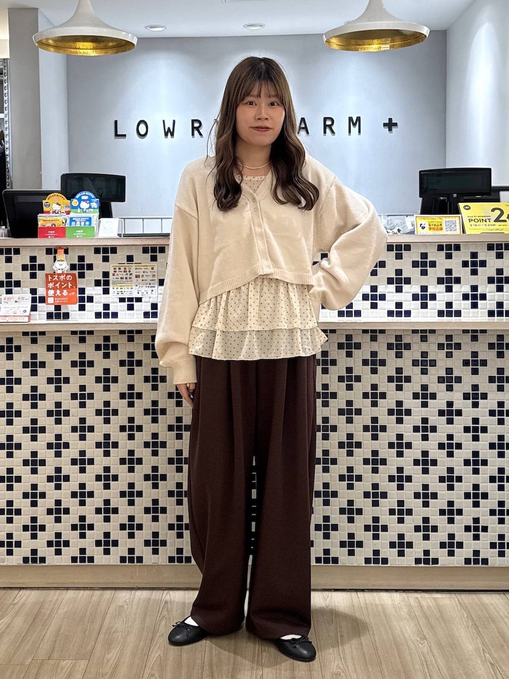 ホワイト系のカーディガン/ボレロ、ホワイト系のTシャツ/カットソー、ブラウン系のスウェットパンツを着用したレディースの秋コーディネートの2枚目の写真