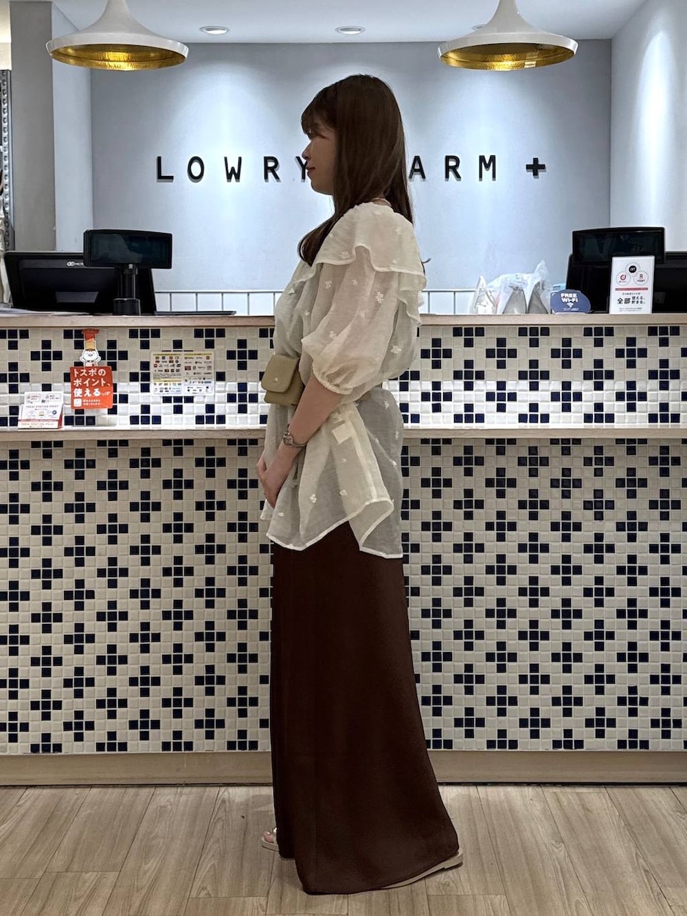 ホワイト系のワンピース、ブラウン系のスカート、ホワイト系のサンダルを着用したレディースの夏コーディネートの4枚目の写真