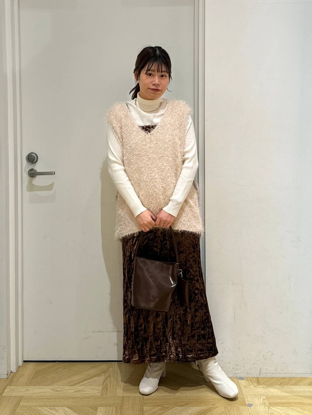 ホワイト系のニット/セーター、ホワイト系のブーツ、ブラウン系のワンピースを着用したレディースの冬コーディネートの4枚目の写真