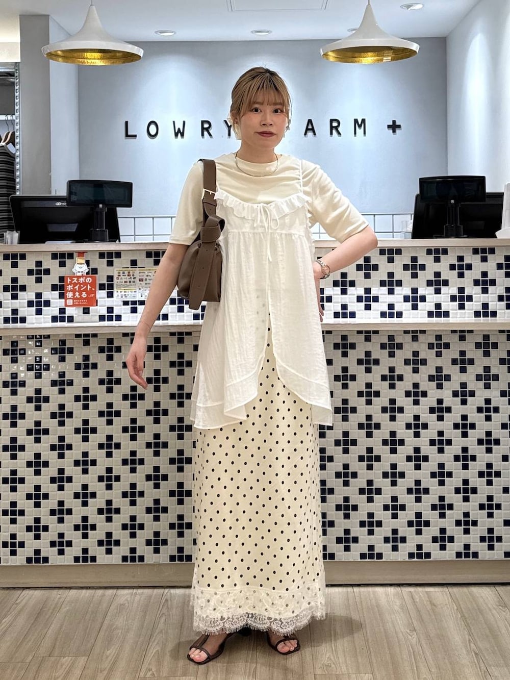 ホワイト系のTシャツ/カットソー、ブラウン系のショルダーバッグ、ブラウン系のサンダルを着用したレディースの春コーディネートの2枚目の写真