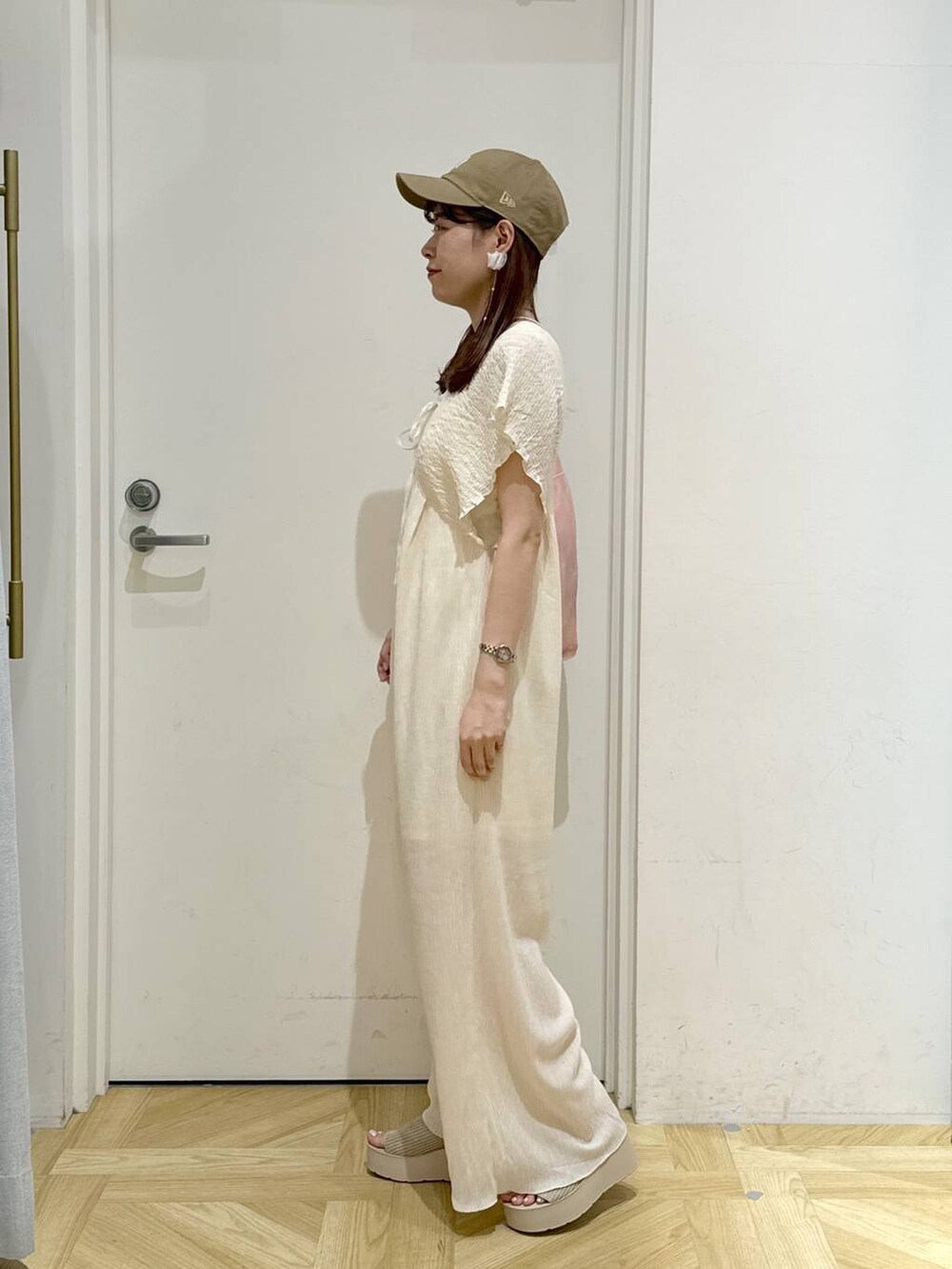 ホワイト系のサンダル、ピンク系のショルダーバッグ、ホワイト系のサロペット/オーバーオールを着用したレディースの夏コーディネートの2枚目の写真