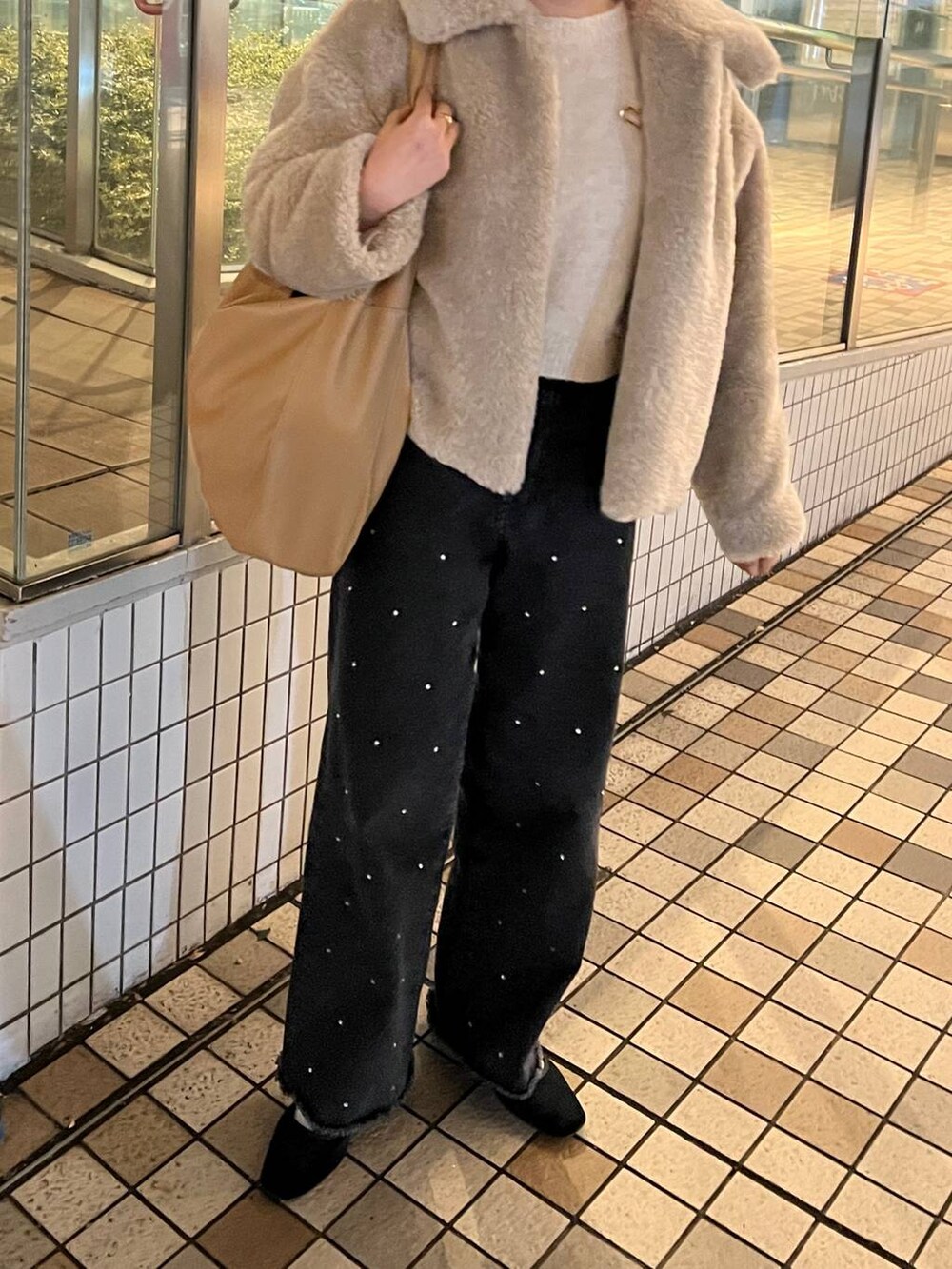 ホワイト系のブルゾン、ホワイト系のニット/セーター、ブラック系のデニムパンツを着用したレディースの冬コーディネートの3枚目の写真