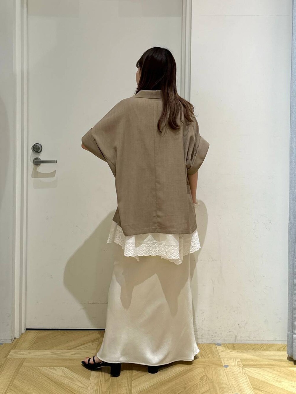 ホワイト系のスカート、ホワイト系のキャミソール、ブラック系のサンダルを着用したレディースの春コーディネートの4枚目の写真