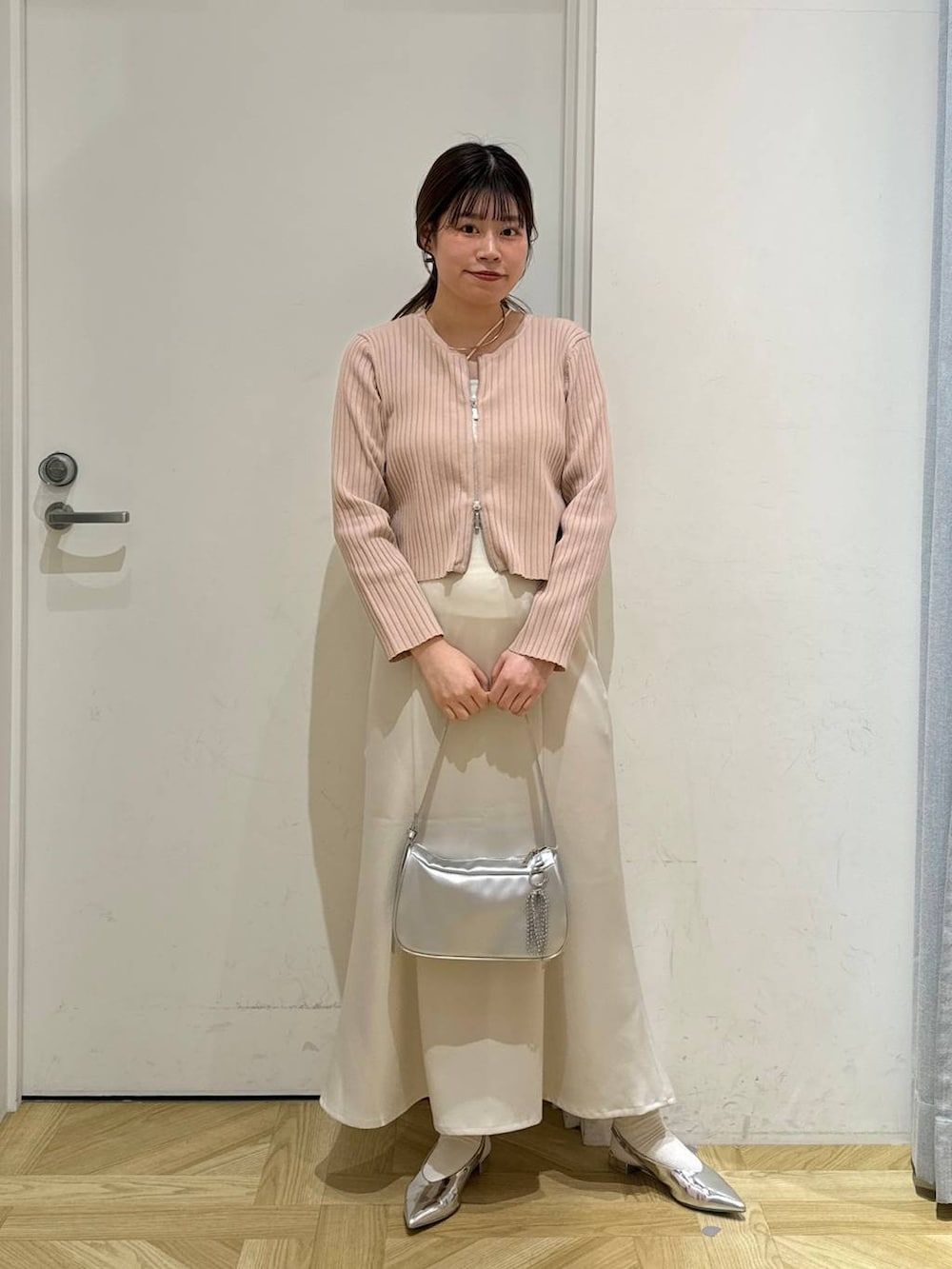 ピンク系のカーディガン/ボレロ、シルバー系のトートバッグ、シルバー系のパンプスを着用したレディースの春コーディネートの3枚目の写真