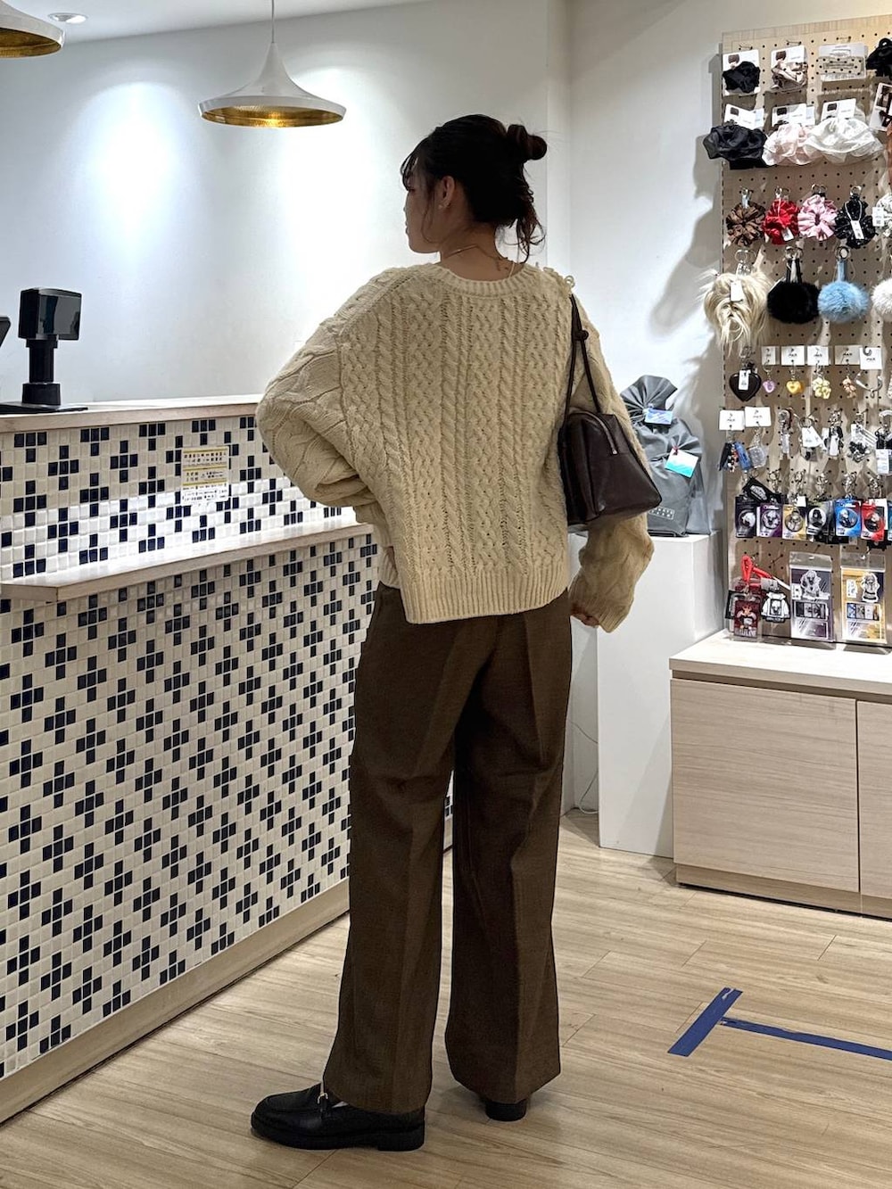 ブラウン系のその他パンツ、ブラック系のローファー、ホワイト系のポロシャツを着用したレディースの秋コーディネートの5枚目の写真