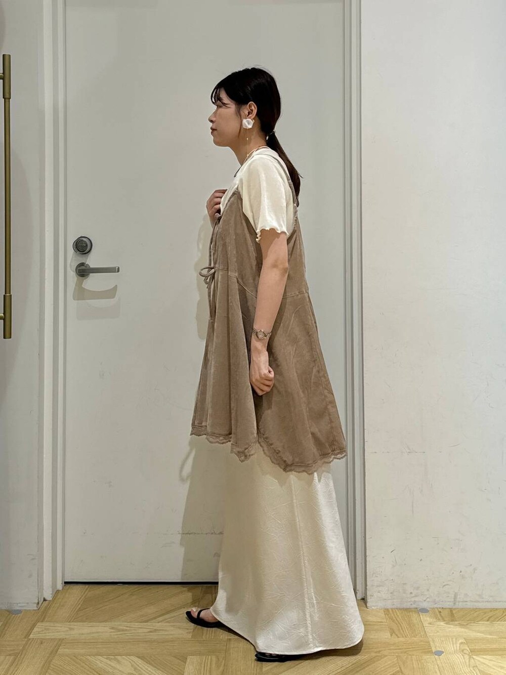 ブラック系のサンダル、ホワイト系のスカート、ホワイト系のカーディガン/ボレロを着用したレディースの夏コーディネートの4枚目の写真