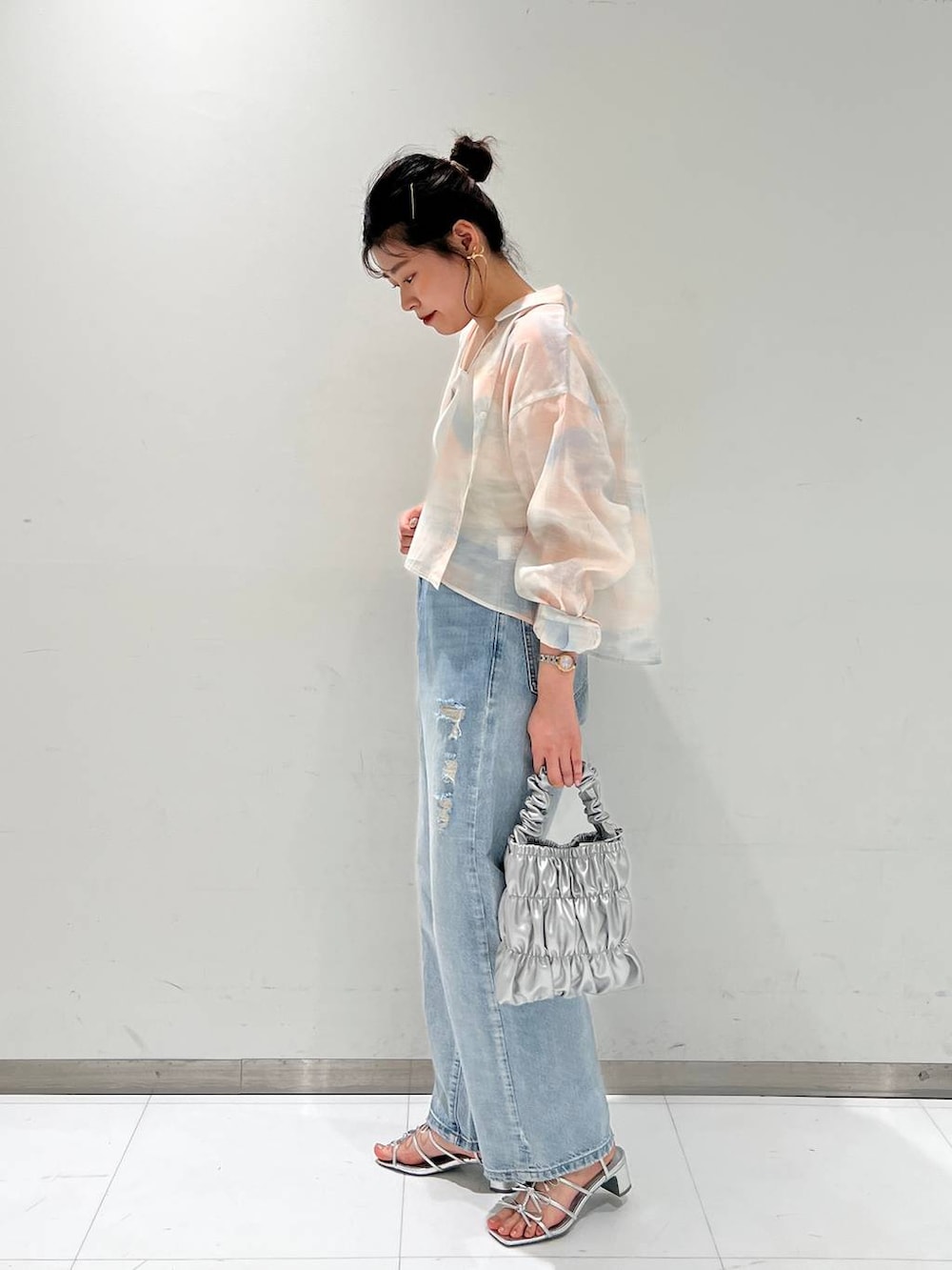 シルバー系のサンダル、ホワイト系のタンクトップ、ブルー系のデニムパンツを着用したレディースの夏コーディネートの2枚目の写真