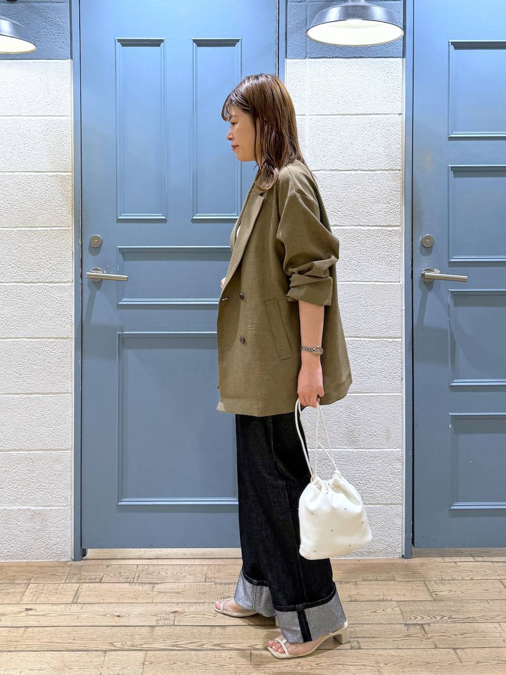 ホワイト系のショルダーバッグ、グレー系のデニムパンツ、ホワイト系のタンクトップを着用したレディースの夏コーディネートの3枚目の写真