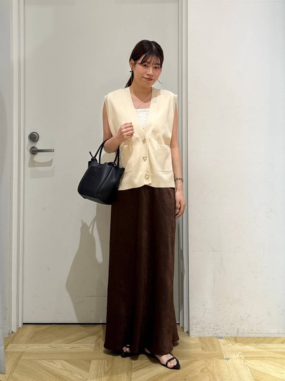 ブラック系のサンダル、ブラウン系のスカート、ブラック系のショルダーバッグを着用したレディースの夏コーディネートの2枚目の写真