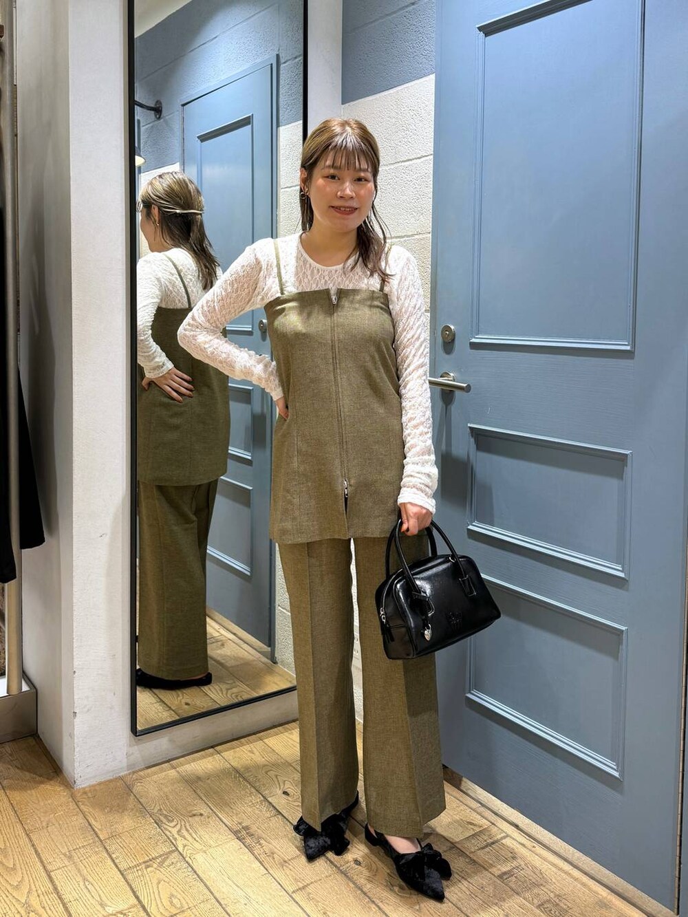 ブラック系のパンプス、ホワイト系のTシャツ/カットソー、ブラウン系のスラックスを着用したレディースの秋コーディネートの3枚目の写真