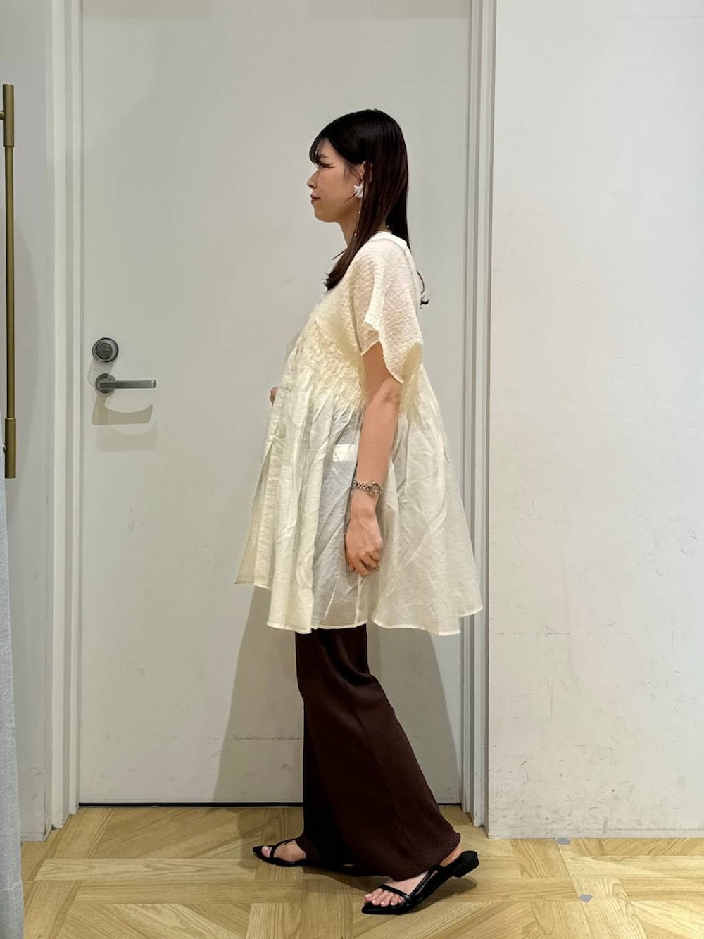 ブラック系のサンダル、ブラウン系のその他パンツ、ホワイト系のシャツ/ブラウスを着用したレディースの夏コーディネートの3枚目の写真