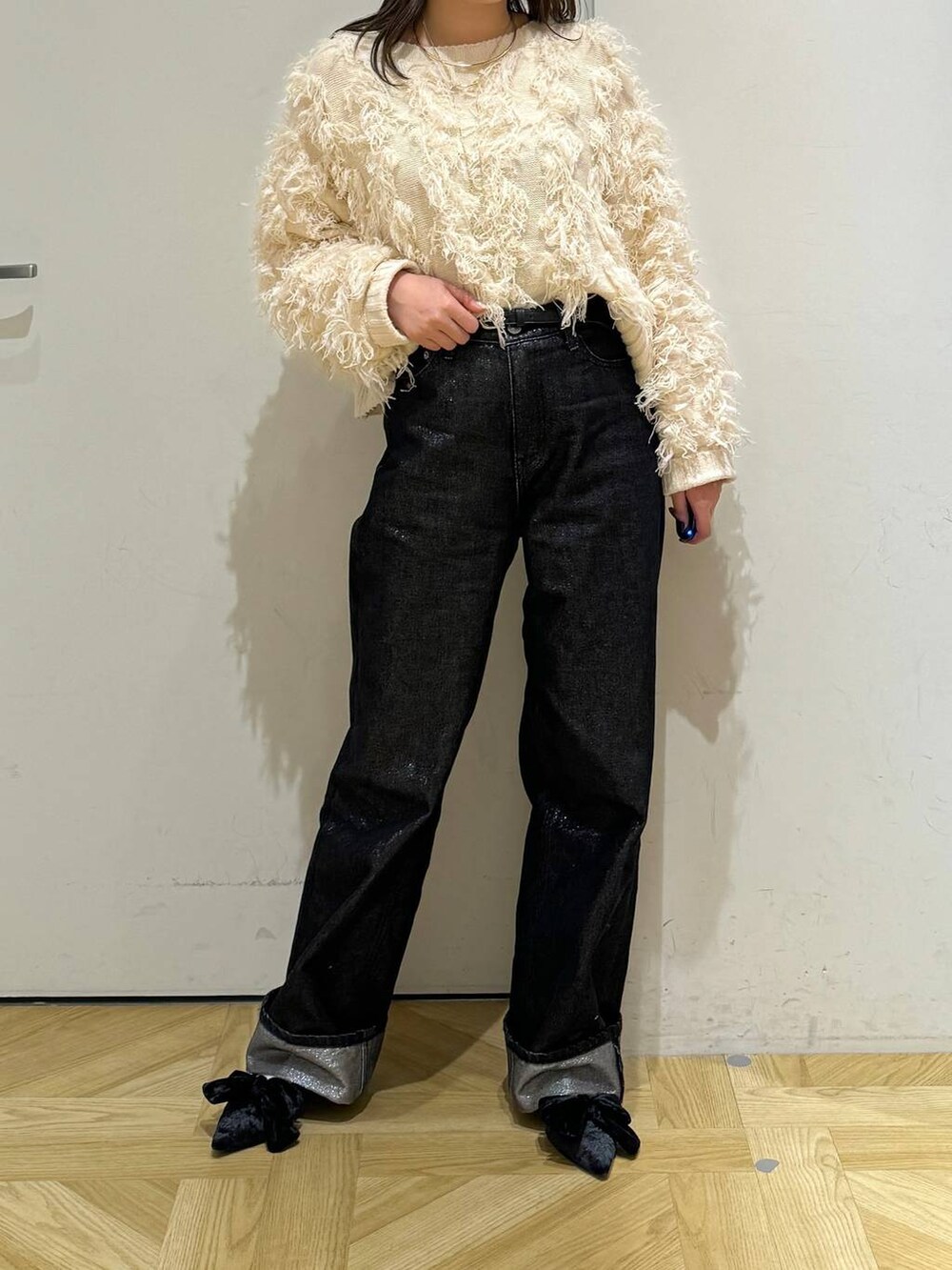 ブラック系のパンプス、グレー系のデニムパンツ、ホワイト系のカーディガン/ボレロを着用したレディースの冬コーディネートの4枚目の写真