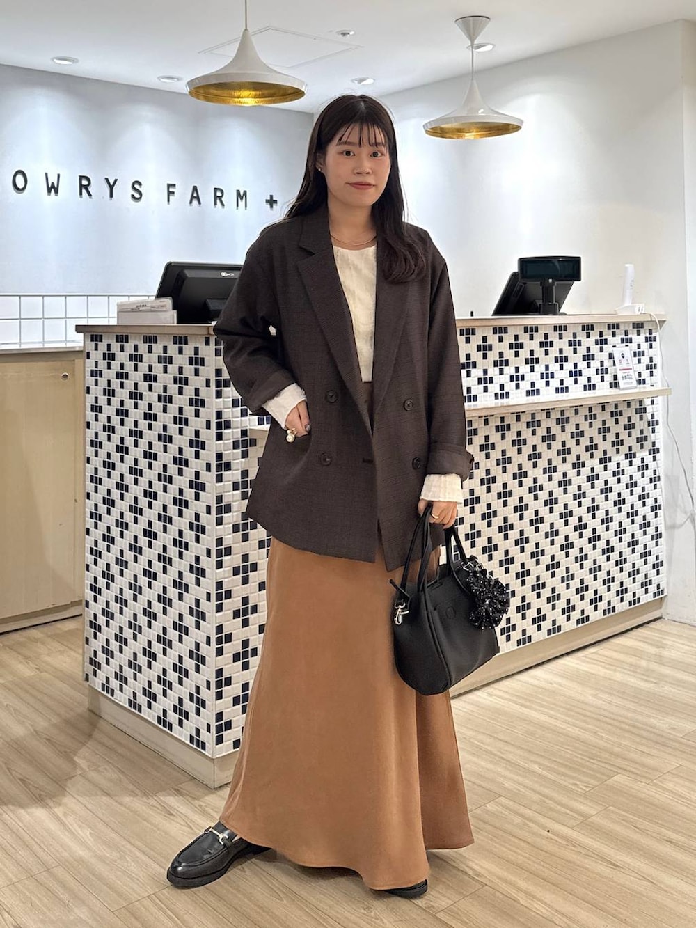 ベージュ系のTシャツ/カットソー、ブラウン系のテーラードジャケット、ブラック系のショルダーバッグを着用したレディースの秋コーディネートの2枚目の写真