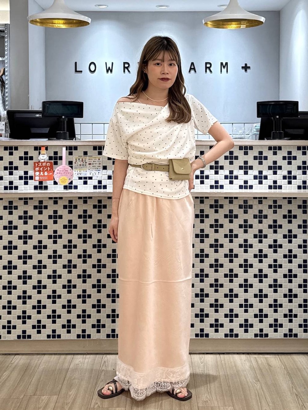 ベージュ系のTシャツ/カットソー、ブラウン系のサンダル、ピンク系のスカートを着用したレディースの夏コーディネートの3枚目の写真