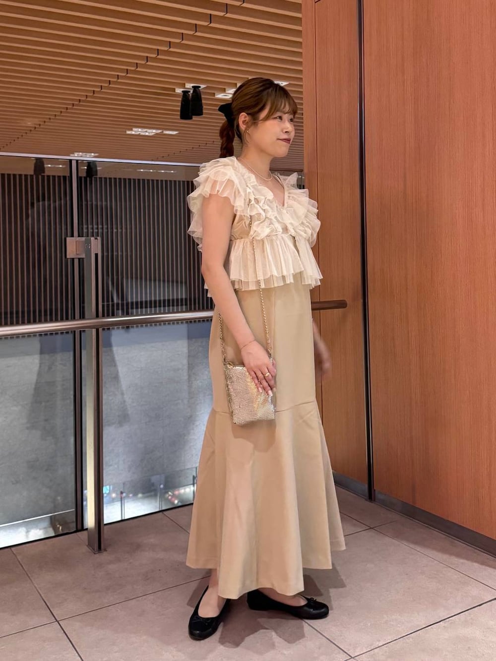 ゴールド系のショルダーバッグ、ゴールド系のワンピース、ベージュ系のその他トップスを着用したレディースの夏コーディネートの3枚目の写真