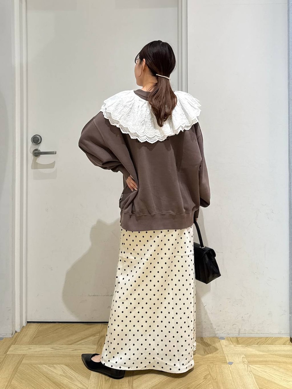 ホワイト系のスカート、ブラック系のボストンバッグ、ブラック系のパンプスを着用したレディースの秋コーディネートの5枚目の写真