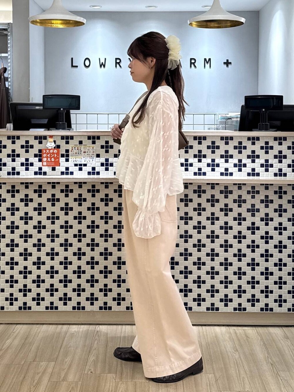 ピンク系のデニムパンツ、ブラウン系のローファー、ブラウン系のショルダーバッグを着用したレディースの春コーディネートの3枚目の写真
