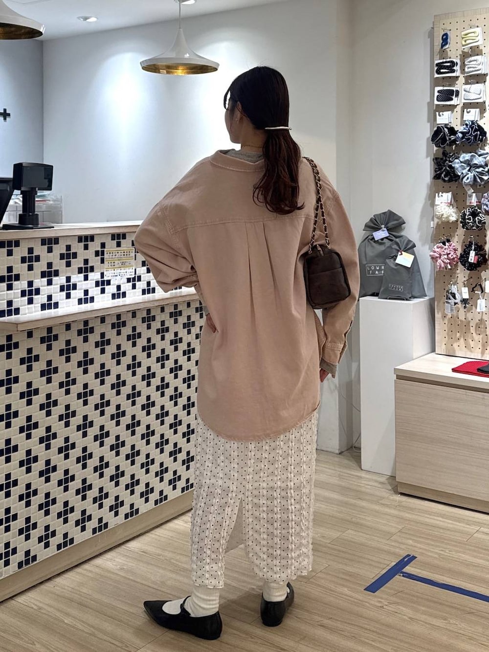 ブラック系のパンプス、ピンク系のシャツ/ブラウス、ブラウン系のショルダーバッグを着用したレディースの春コーディネートの3枚目の写真