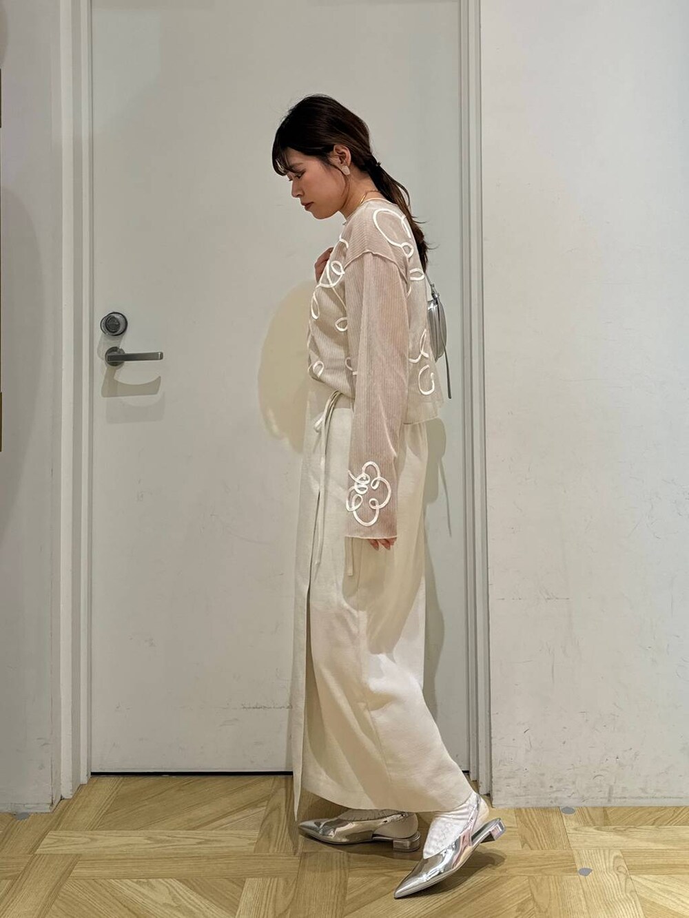 ホワイト系のスカート、ホワイト系のテーラードジャケット、シルバー系のトートバッグを着用したレディースの春コーディネートの8枚目の写真