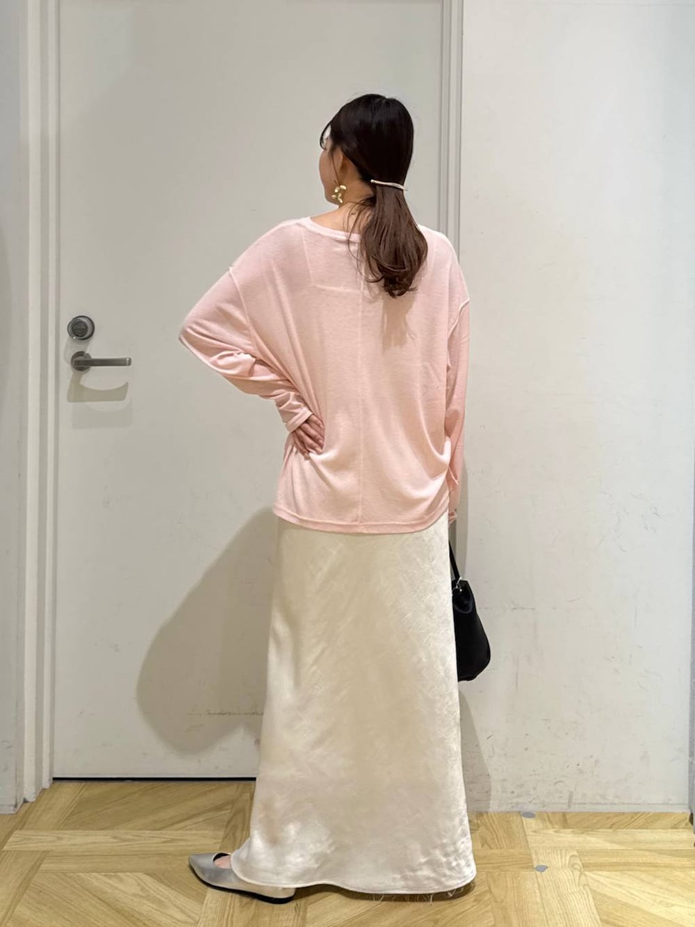 ホワイト系のスカート、ブラック系のショルダーバッグ、シルバー系のパンプスを着用したレディースの夏コーディネートの4枚目の写真