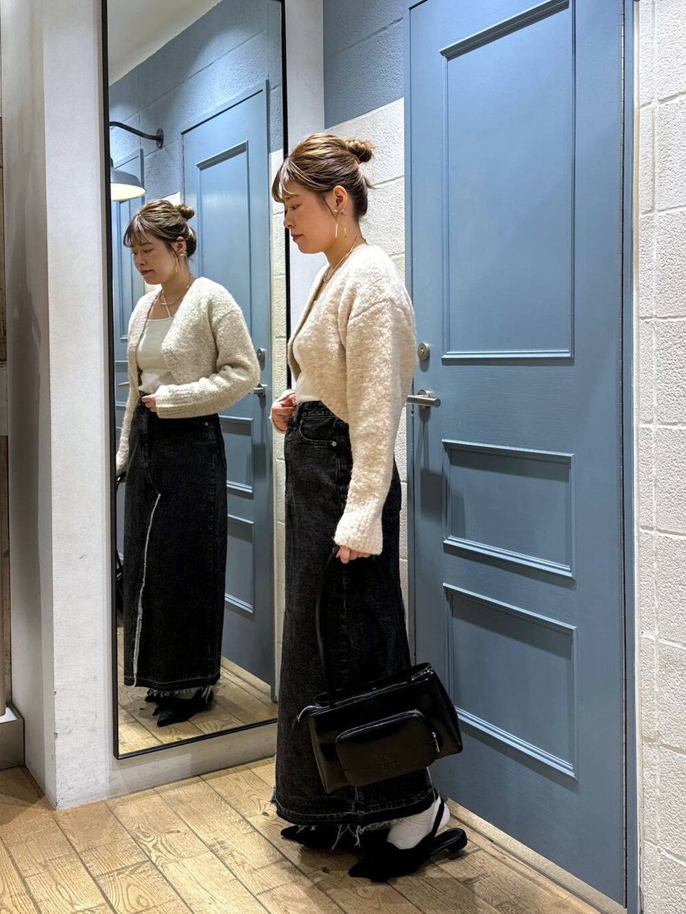 ブラック系のパンプス、ホワイト系のキャミソール、ブラック系のスカートを着用したレディースの秋コーディネートの2枚目の写真