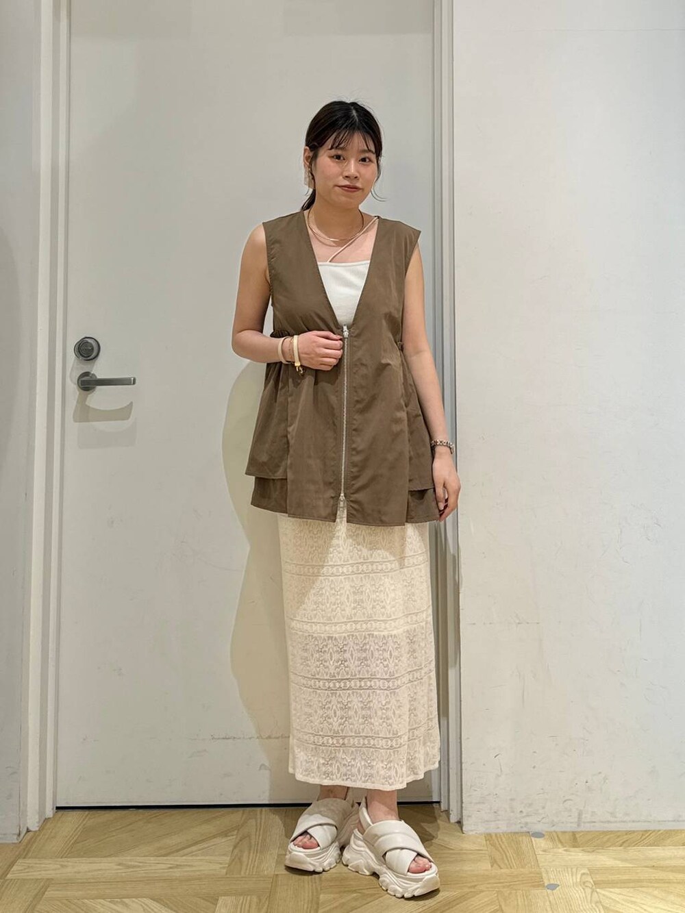 ホワイト系のキャミソール、ホワイト系のサンダル、ホワイト系のスカートを着用したレディースの夏コーディネートの2枚目の写真