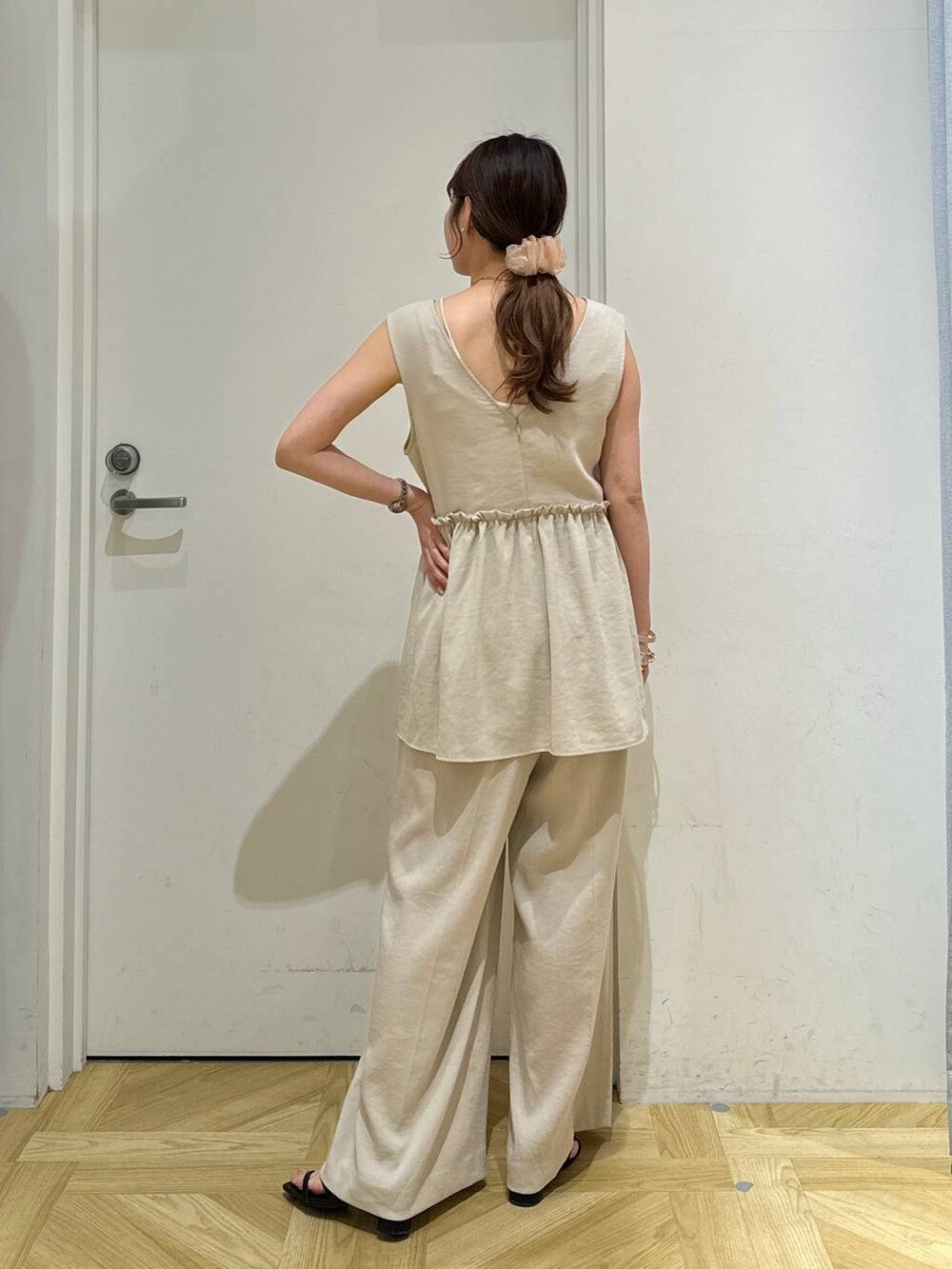 ホワイト系のキャミソール、ブラック系のサンダル、ホワイト系のサロペット/オーバーオールを着用したレディースの夏コーディネートの3枚目の写真