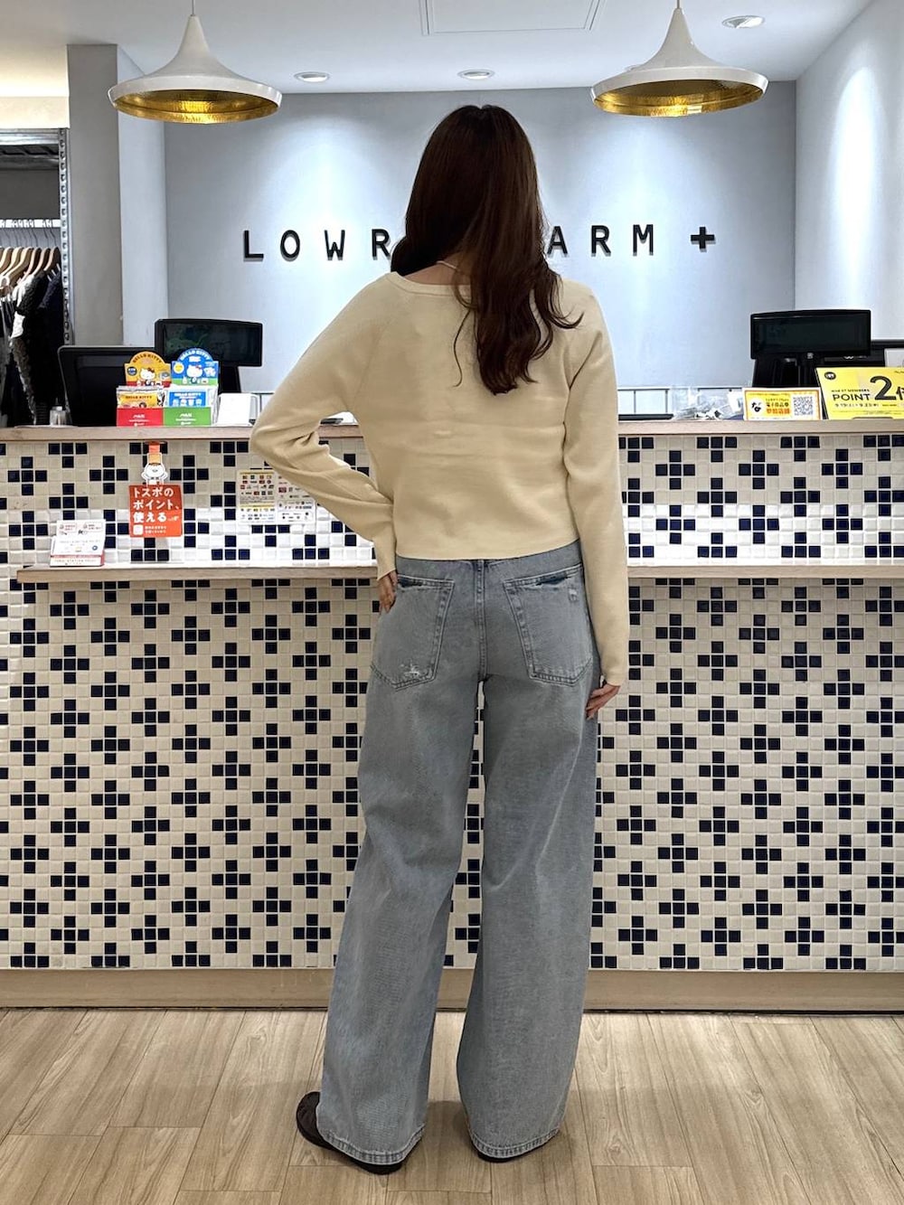 ホワイト系のニット/セーター、ブラウン系のローファー、ブルー系のデニムパンツを着用したレディースの秋コーディネートの5枚目の写真