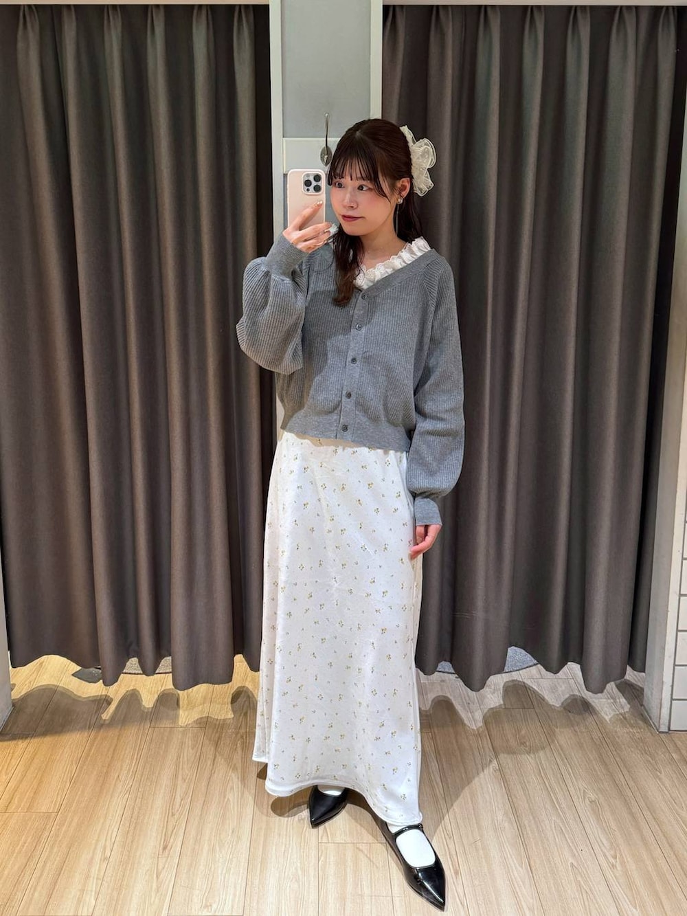 ホワイト系のスカート、ブラック系のパンプス、グレー系のカーディガン/ボレロを着用したレディースの冬コーディネートの2枚目の写真