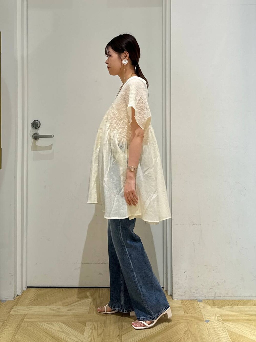 ホワイト系のサンダル、ブルー系のデニムパンツ、ホワイト系のシャツ/ブラウスを着用したレディースの夏コーディネートの3枚目の写真