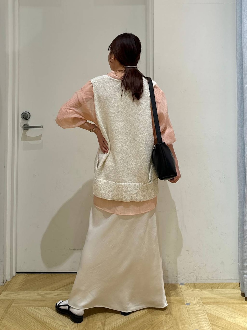 ブラック系のサンダル、ホワイト系のニット/セーター、ブラック系のショルダーバッグを着用したレディースの春コーディネートの5枚目の写真