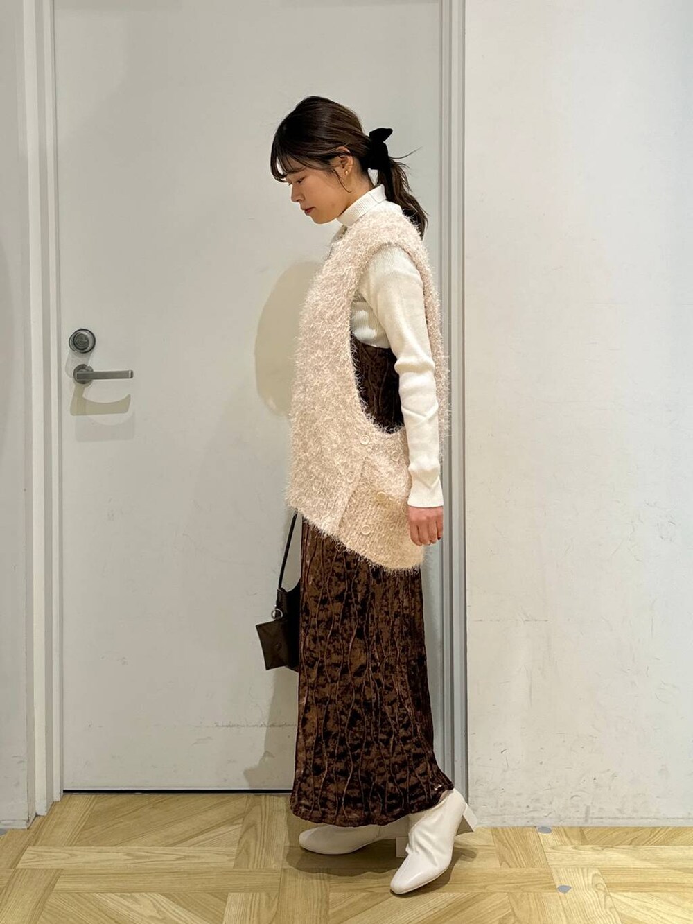 ホワイト系のニット/セーター、ホワイト系のブーツ、ブラウン系のワンピースを着用したレディースの冬コーディネートの5枚目の写真