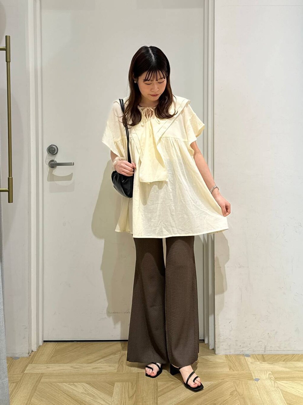 ブラック系のサンダル、ブラック系のショルダーバッグ、ブラウン系のその他パンツを着用したレディースの春コーディネートの2枚目の写真