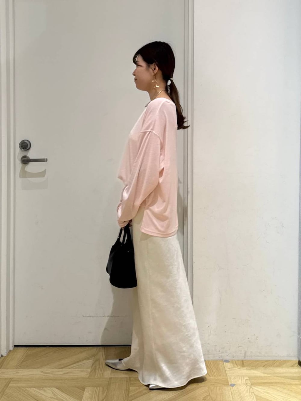 ホワイト系のスカート、ブラック系のショルダーバッグ、シルバー系のパンプスを着用したレディースの夏コーディネートの3枚目の写真