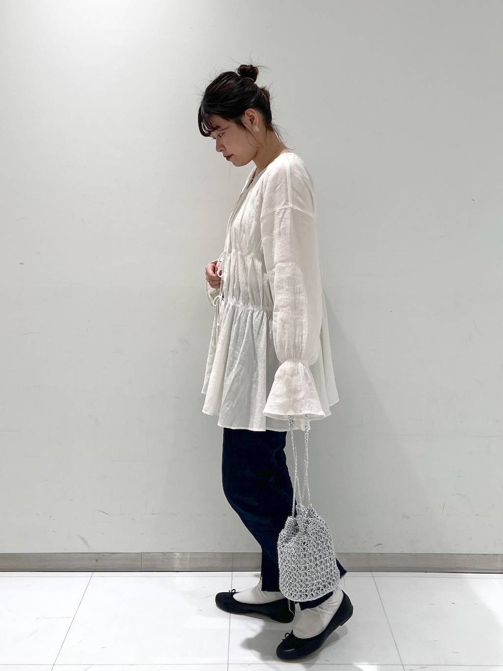 ホワイト系のシャツ/ブラウス、ブラック系のバレエシューズ、ブルー系のデニムパンツを着用したレディースの春コーディネートの3枚目の写真