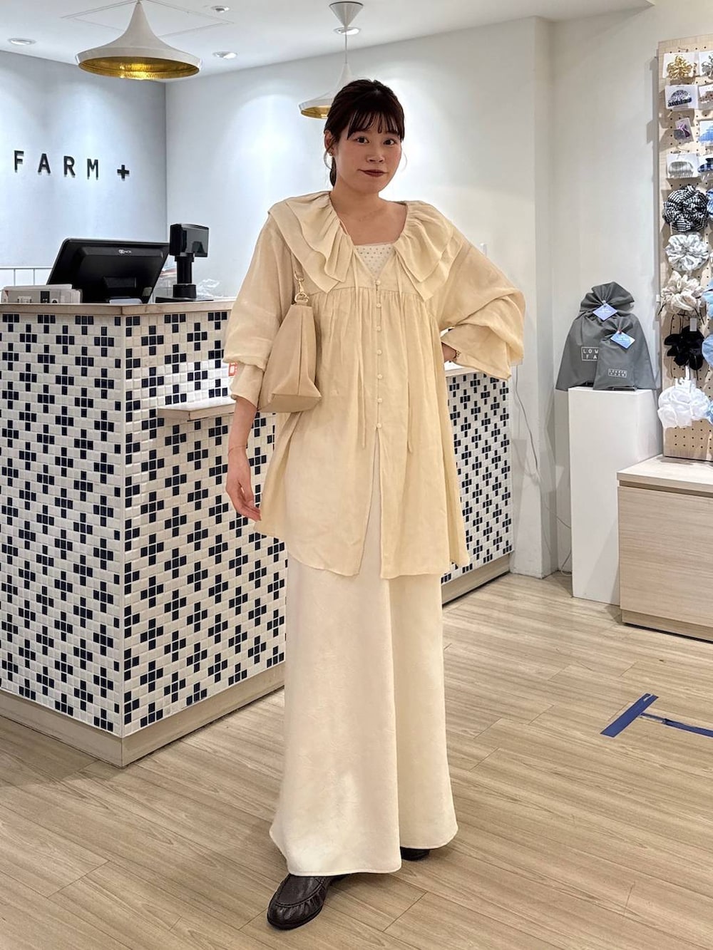 ホワイト系のスカート、ベージュ系のショルダーバッグ、ブラウン系のローファーを着用したレディースの春コーディネートの4枚目の写真