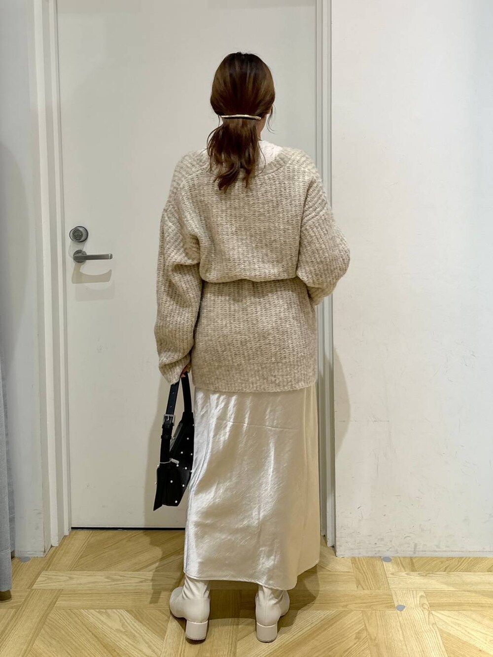 ホワイト系のスカート、ホワイト系のブーツ、ホワイト系のTシャツ/カットソーを着用したレディースの秋コーディネートの4枚目の写真